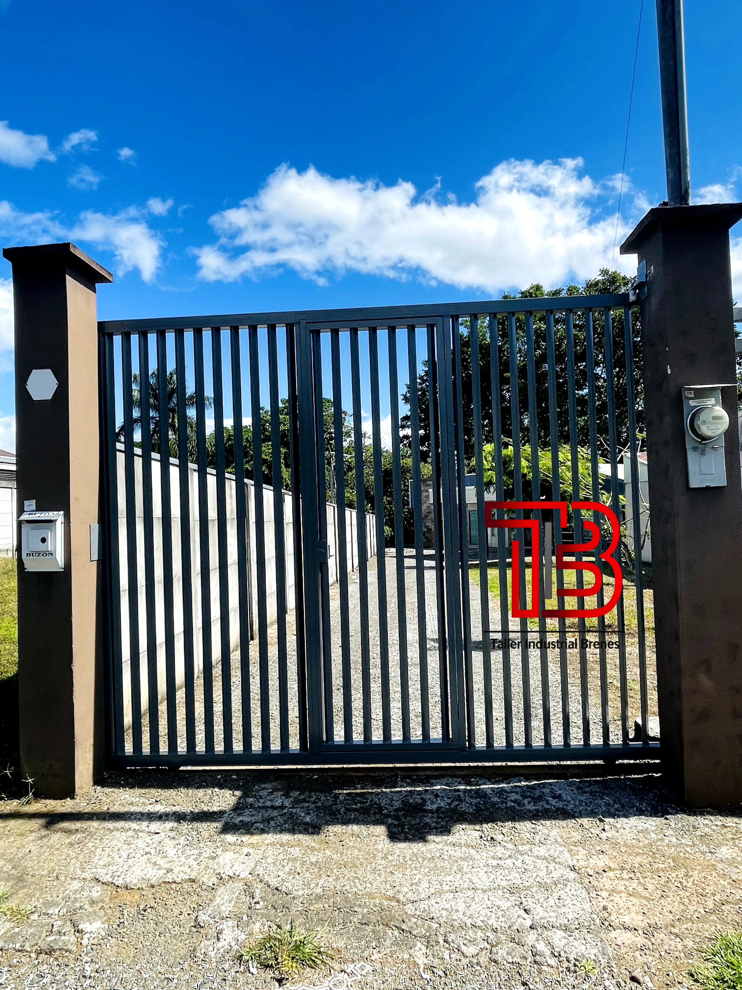 Portón Vehicular de Doble Hoja Abatible con Diseño de Barrotes Verticales - Vista 1