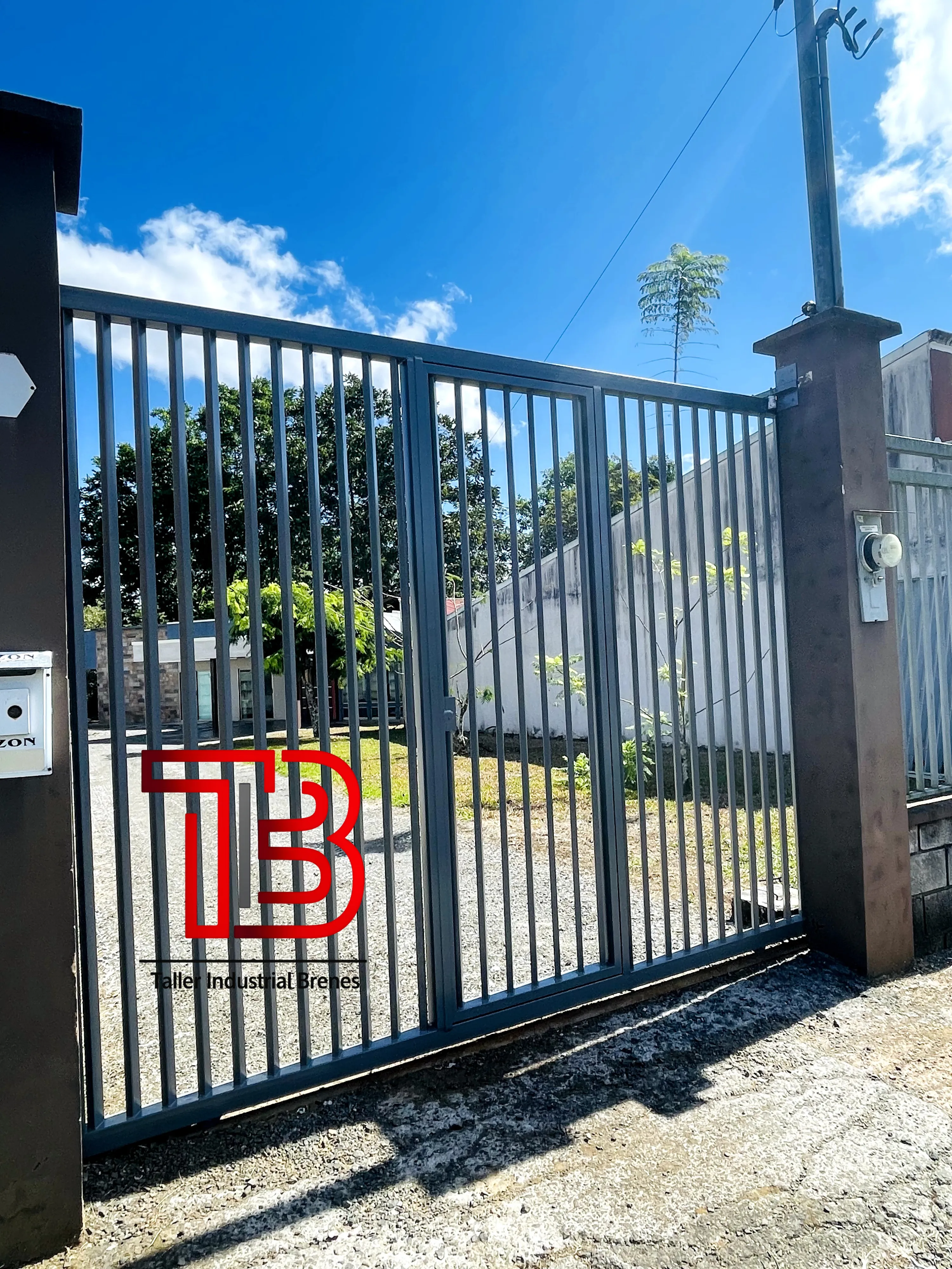 Portón Vehicular de Doble Hoja Abatible con Diseño de Barrotes Verticales - Vista 3